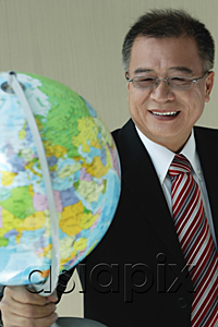 AsiaPix - A man in suit holds a globe