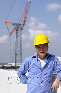 AsiaPix - A man with a yellow helmet smiles at the camera as he works