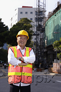 AsiaPix - A man with a yellow helmet smiles at the camera, hands crossed