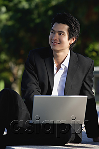 AsiaPix - A man uses his laptop in the park
