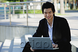 AsiaPix - A man uses his laptop outdoors