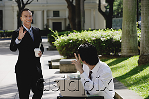 AsiaPix - Two men wave at each other in the park