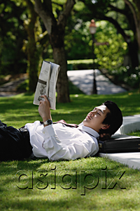 AsiaPix - A man lies down and reads the newspaper in the park