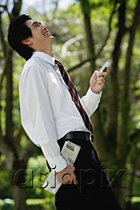 AsiaPix - A man laughs as he checks his cellphone in the park