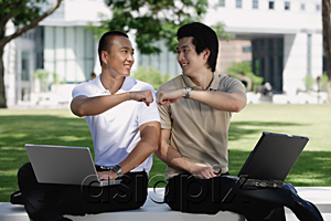 AsiaPix - Two men use their laptops in the park