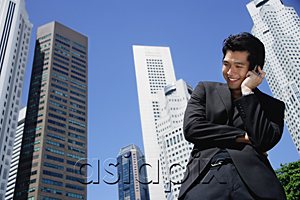 AsiaPix - A man talks on his cellphone with skyscrapers in the background