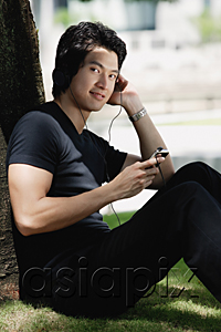 AsiaPix - A man listens to music on a mp3 player in the park