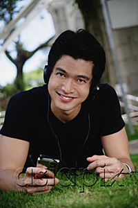 AsiaPix - A man looks at the camera as he listens to music on a mp3 player in the park