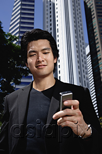 AsiaPix - A man checks his phone while outdoors in the city