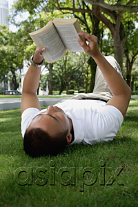 AsiaPix - A man lies down and reads in the park