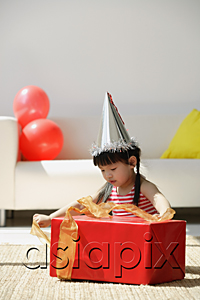 AsiaPix - A young girl unwraps a birthday present