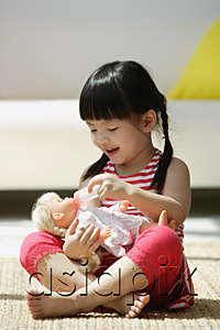 AsiaPix - A small girl plays with a doll