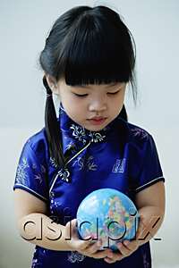AsiaPix - A small girl in blue silk cheongsam holds a globe