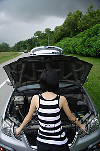 AsiaPix - A woman checks under the hood of her car