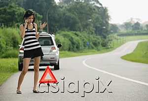 AsiaPix - A woman with car trouble calls for help on her cellphone