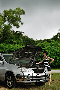 AsiaPix - A woman checks under the hood of her car