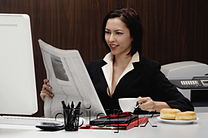 AsiaPix - A woman takes a break at work and reads the newspaper