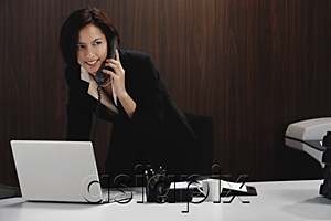 AsiaPix - A woman talks on the phone while she is at her desk