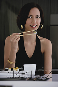 AsiaPix - A woman looks at the camera as she eats sushi