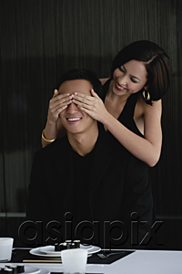 AsiaPix - A woman covers her boyfriends eyes as she prepares to surprise him with dinner