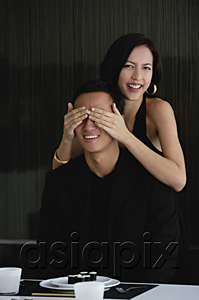 AsiaPix - A woman covers her boyfriends eyes as she prepares to surprise him with dinner