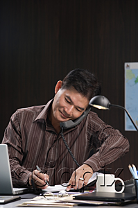 AsiaPix - A man talks on the phone as he works