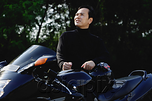 AsiaPix - A man stands behind his motorbike