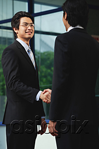 AsiaPix - Two men wearing suits shake hands