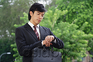 AsiaPix - A man in a suit checks his watch for the time