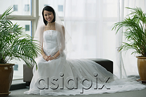 AsiaPix - A bride with a white wedding gown sits down and smiles at the camera