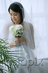 AsiaPix - A bride smiles as she holds a bouquet of flowers