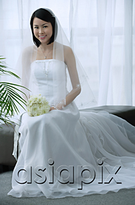 AsiaPix - A bride with a white wedding gown sits down and smiles at the camera