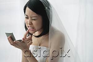 AsiaPix - A bride checks her teeth in a mirror