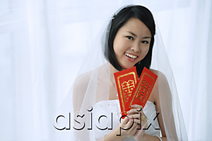 AsiaPix - A bride smiles at the camera and holds out two red envelopes