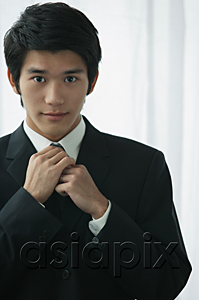 AsiaPix - A groom wearing a suit looks at the camera