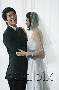 AsiaPix - A newlywed couple stand with their arms around each other