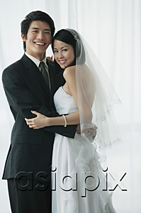 AsiaPix - A newlywed couple hug and smile at the camera