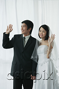AsiaPix - A newlywed couple hold hands and wave