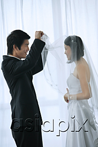 AsiaPix - The groom lifts the brides veil to kiss her