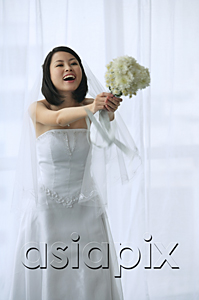 AsiaPix - A bride holds out a bouquet of flowers