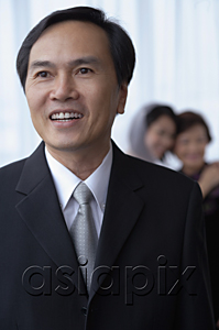 AsiaPix - A man smiles while a bride and her mother hug in the background