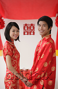 AsiaPix - A newlywed couple hold hands and smile at the camera