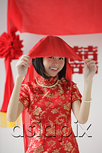 AsiaPix - A bride wearing a red silk dress smiles at the camera