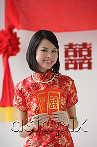 AsiaPix - A bride smiles as she holds two red envelopes