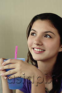 AsiaPix - A teenage girl smiles as she has a drink