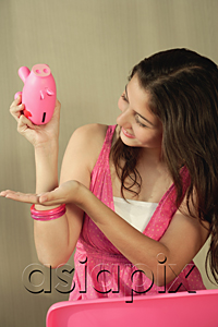 AsiaPix - A teenage girl tries to get money from a piggy bank
