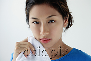 AsiaPix - A young woman looks at the camera as she washes her face