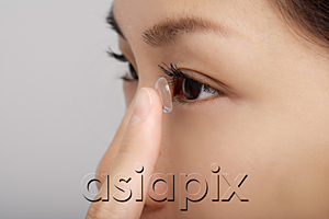 AsiaPix - A young woman puts a contact lens in