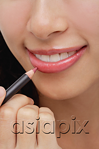 AsiaPix - A young woman applies lip pencil