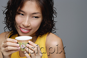 AsiaPix - A woman smiles as she has a cup of tea